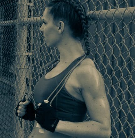 Personal Trainer standing against fence