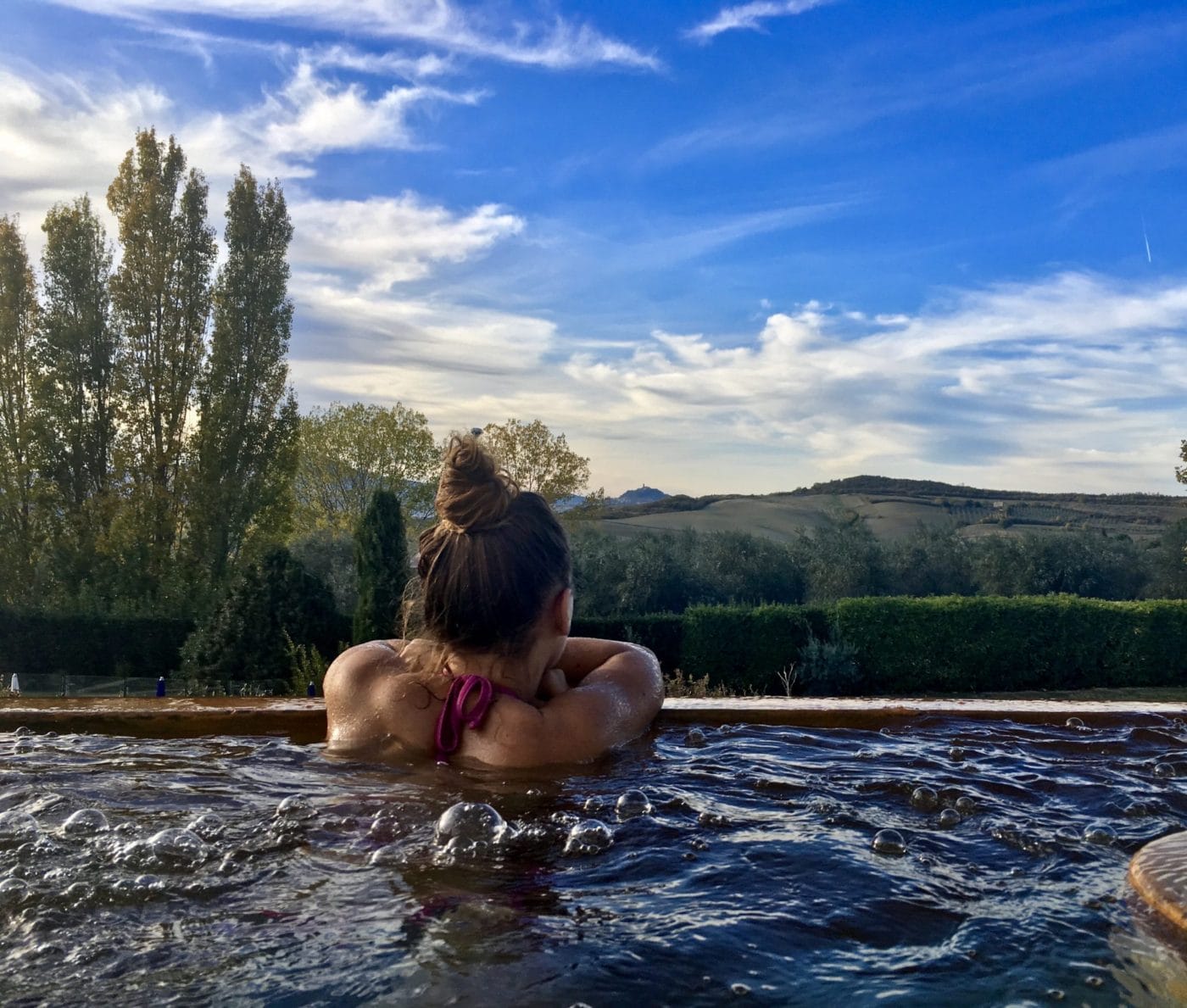 Woman looking at the Tuscan panorama at the spa