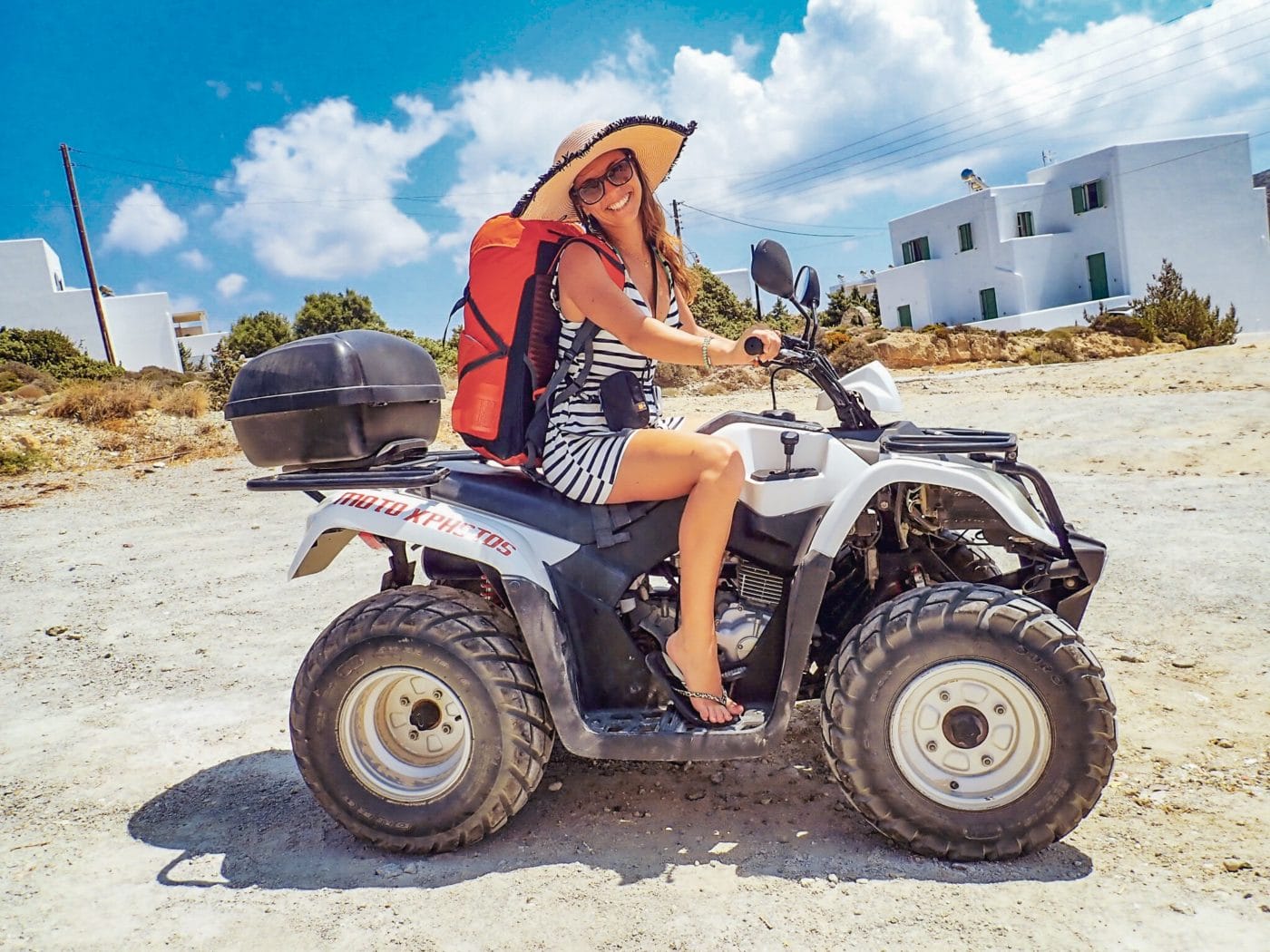 girl on quad or ATV with backpack getting ready to travel around the greek islands
