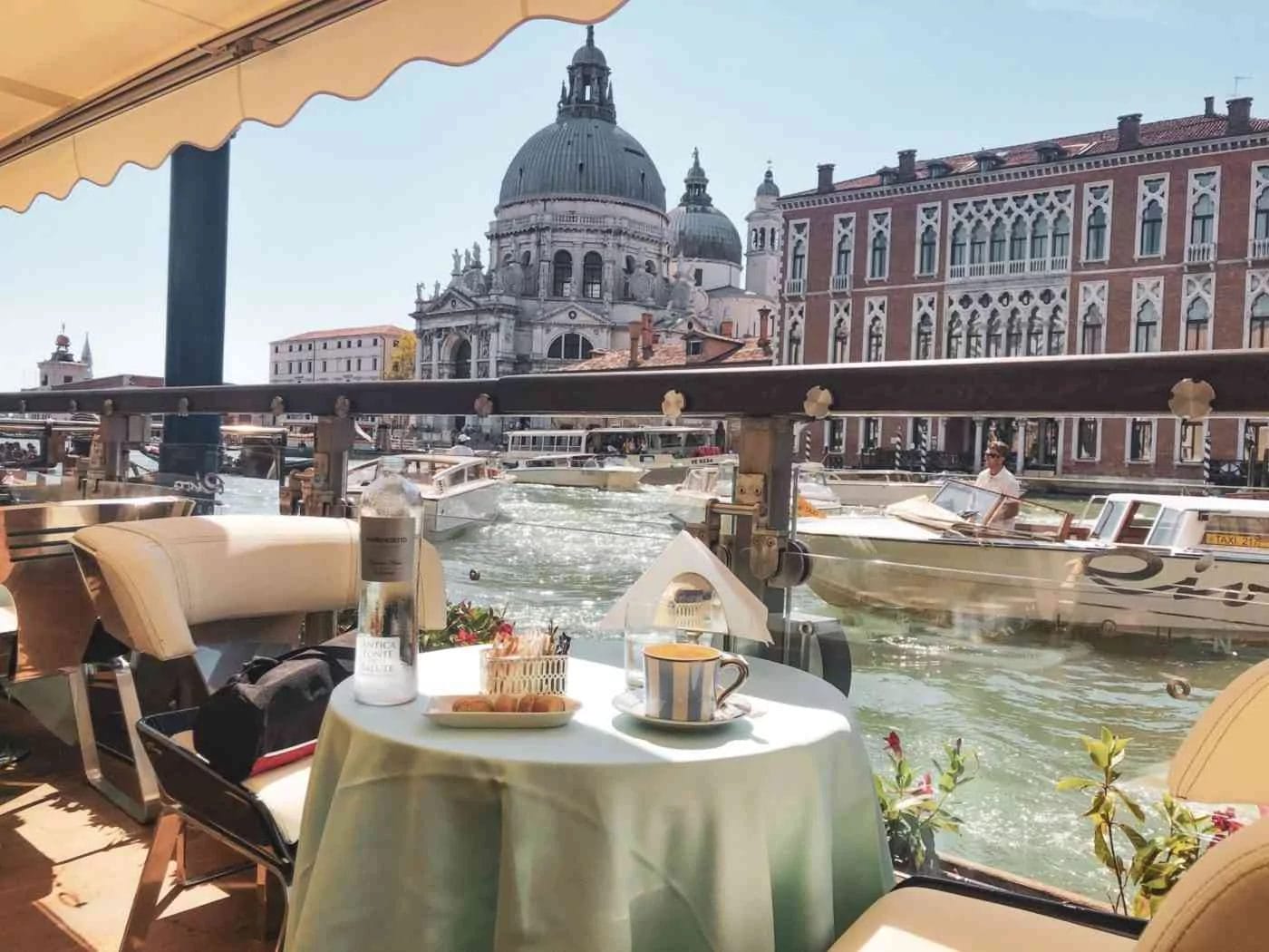 An empty table with a cappuccino on the waterfront of the Gritti Terrace Hotel in Venice Italy