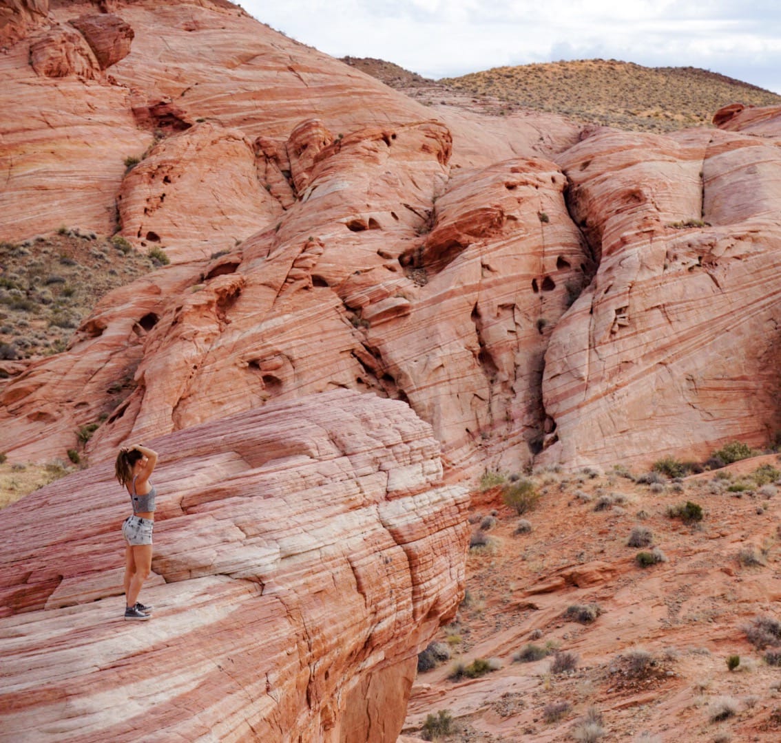 woman standing on a rock overlooking the Valley of Fire State Park in Nevada, USA