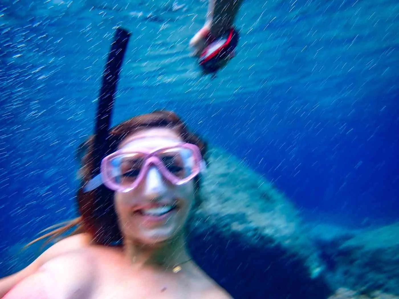 underwater photography of a girl with mask who is smiling for camera