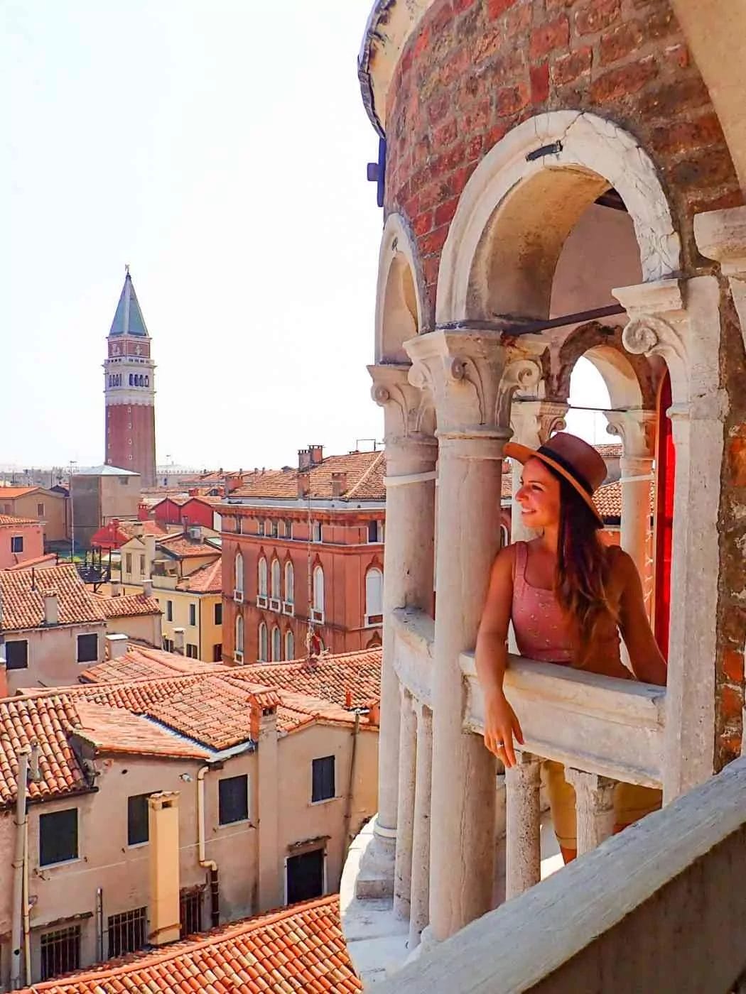 lady at Scala Contarini del Bovolo in the tower looking out onto the venetian skyline