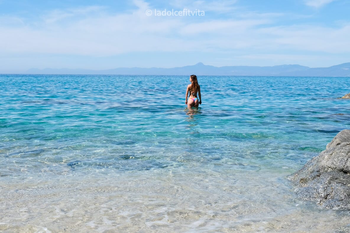 woman bathing in turquoise waters in a beach in Calabria Italy
