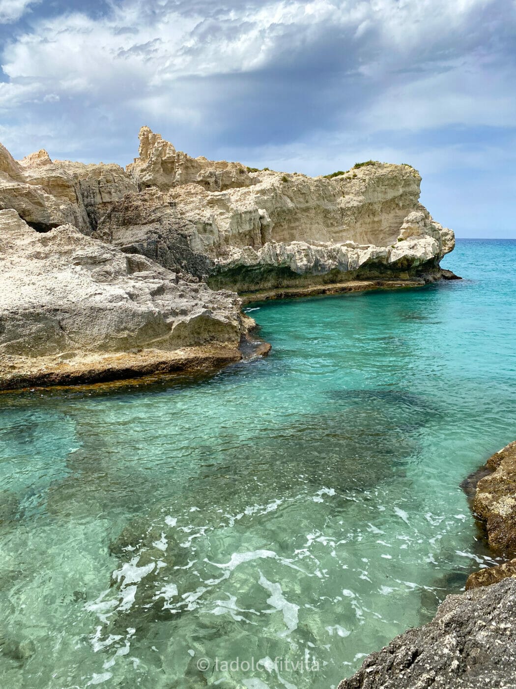 rocky reef in the turquoise waters of riaci beach in Calabria, Italy