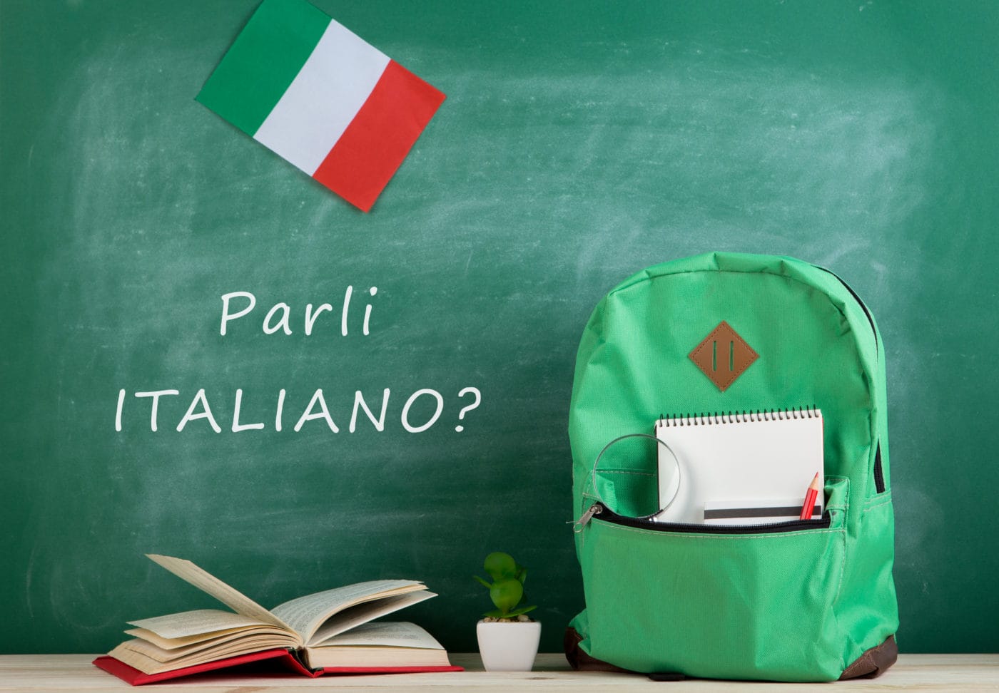 green backpack, blackboard with text "Parli italiano?", flag of Italy, books and notebooks