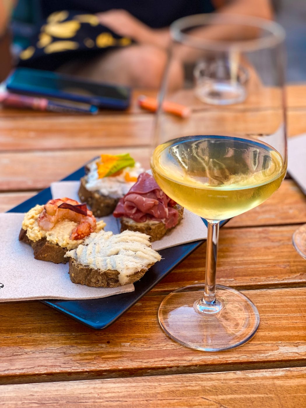 a selection of your typical cicchetti and glass of white wine