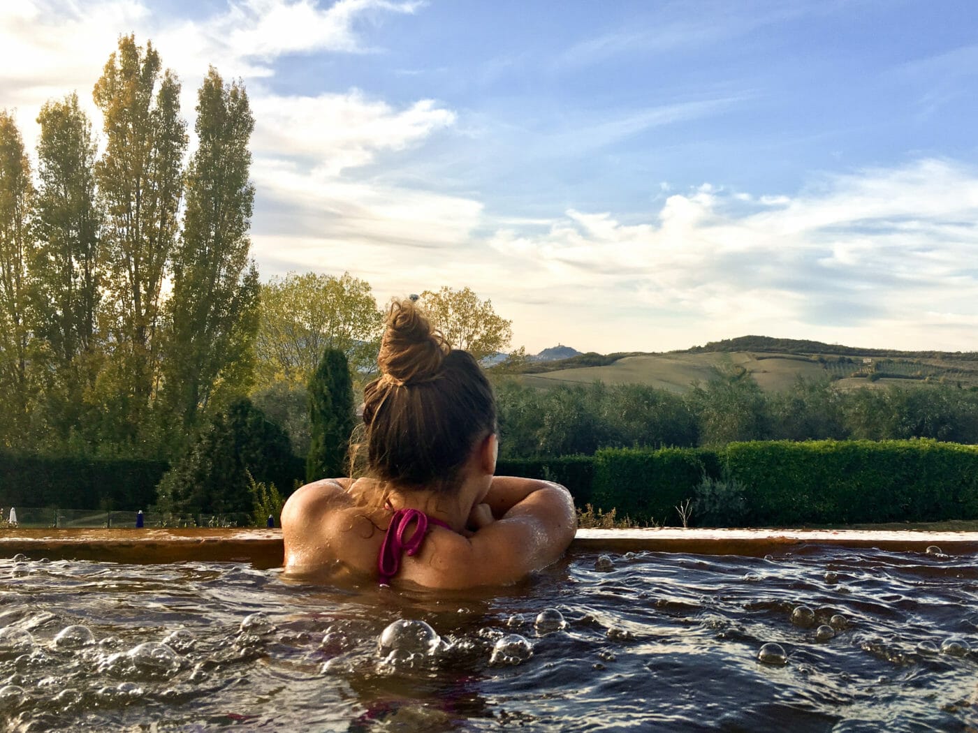 woman soaking in an infinity pool at fonteverde resort in tuscany