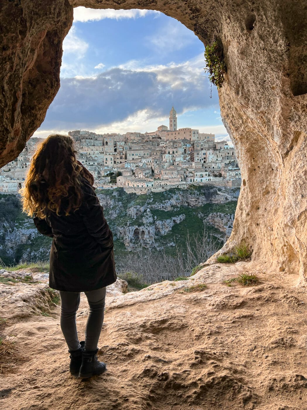 woman visiting matera italy and its caves in the murgia park of rupestrian churches