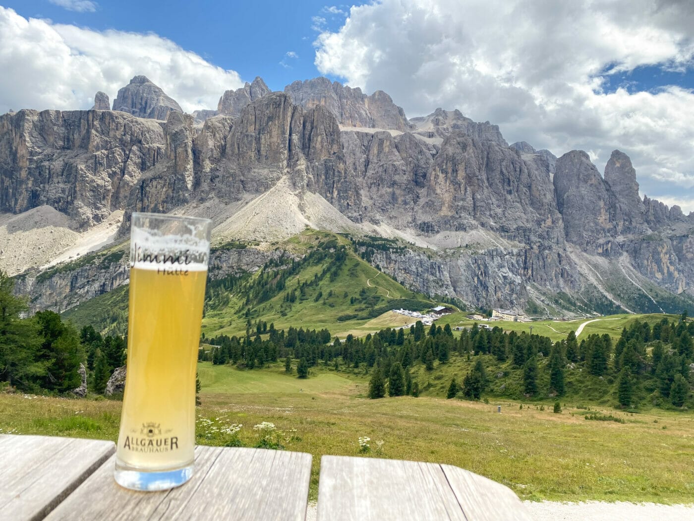 beer glass at a mountain hut with the beautiful dolomite mountains in background at passo gardena
