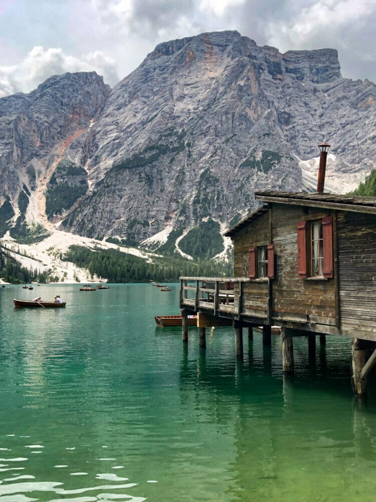 charming wooden boathouse at emerald lago di braies with magnificent dolomite mountains in background