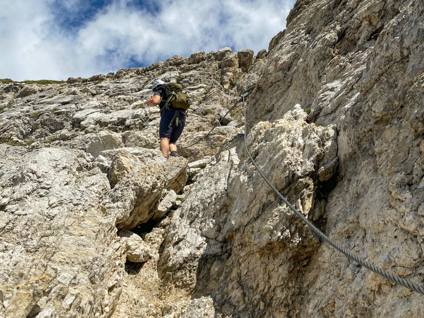 hiker above that is climbing of via ferrata in the dolomites