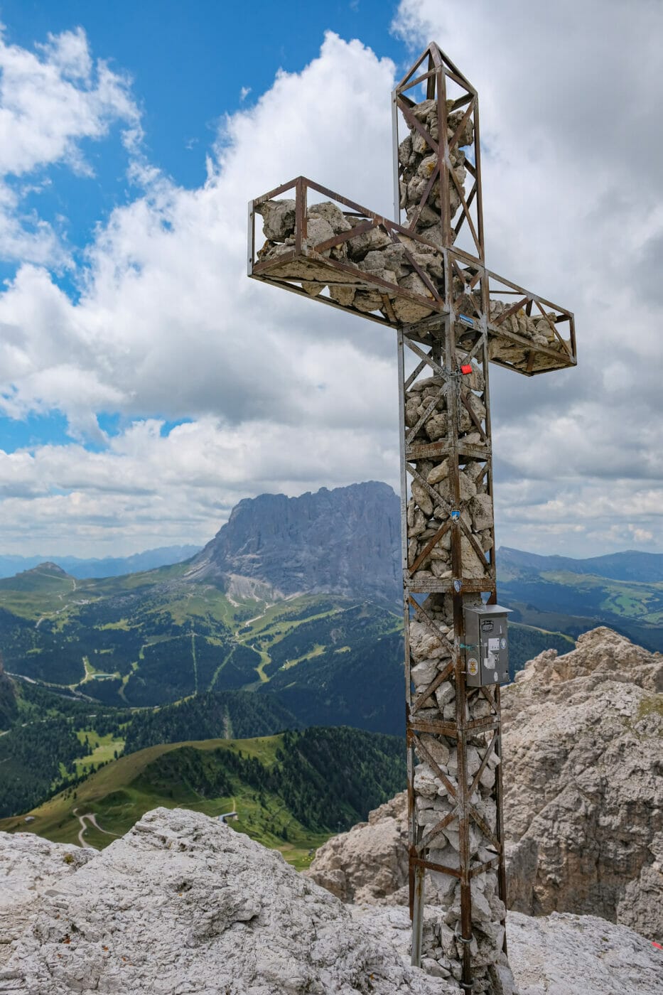 a cross made with stones on the summit of a mountain peak in the dolomites