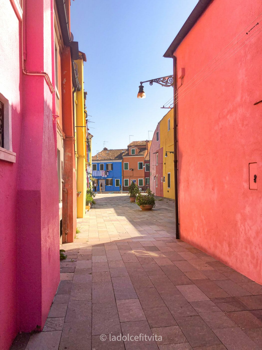 an alley on Burano island in venice with its very colorful buildings