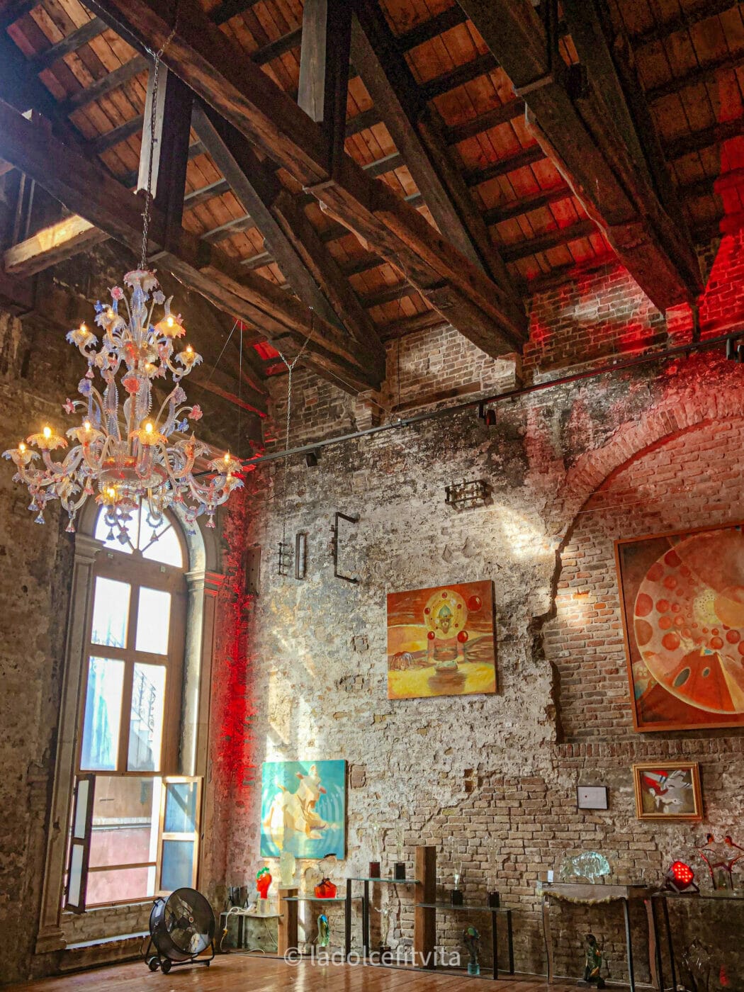cathedral room with glass chandelier and brick wall in murano venice