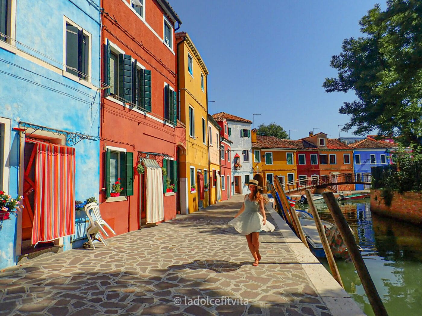 girl twirling in the alleys of colorful burano island in venice