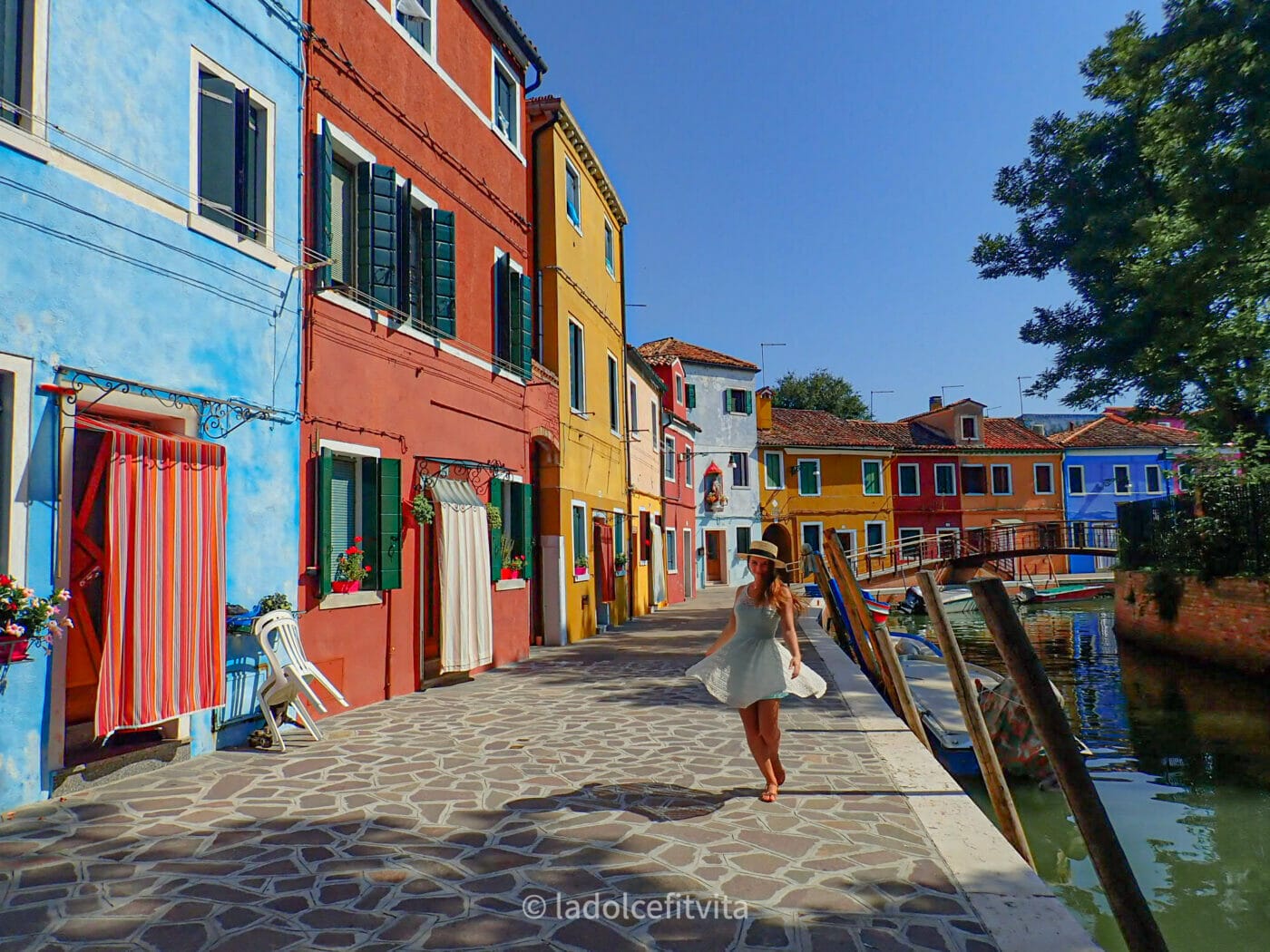 cheerful girl twirling in the alleys of colorful Burano Island in Venice, Italy