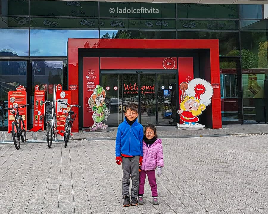 kids posing for picture in front of the Loacker Factory entrance in Heinfels, Austria