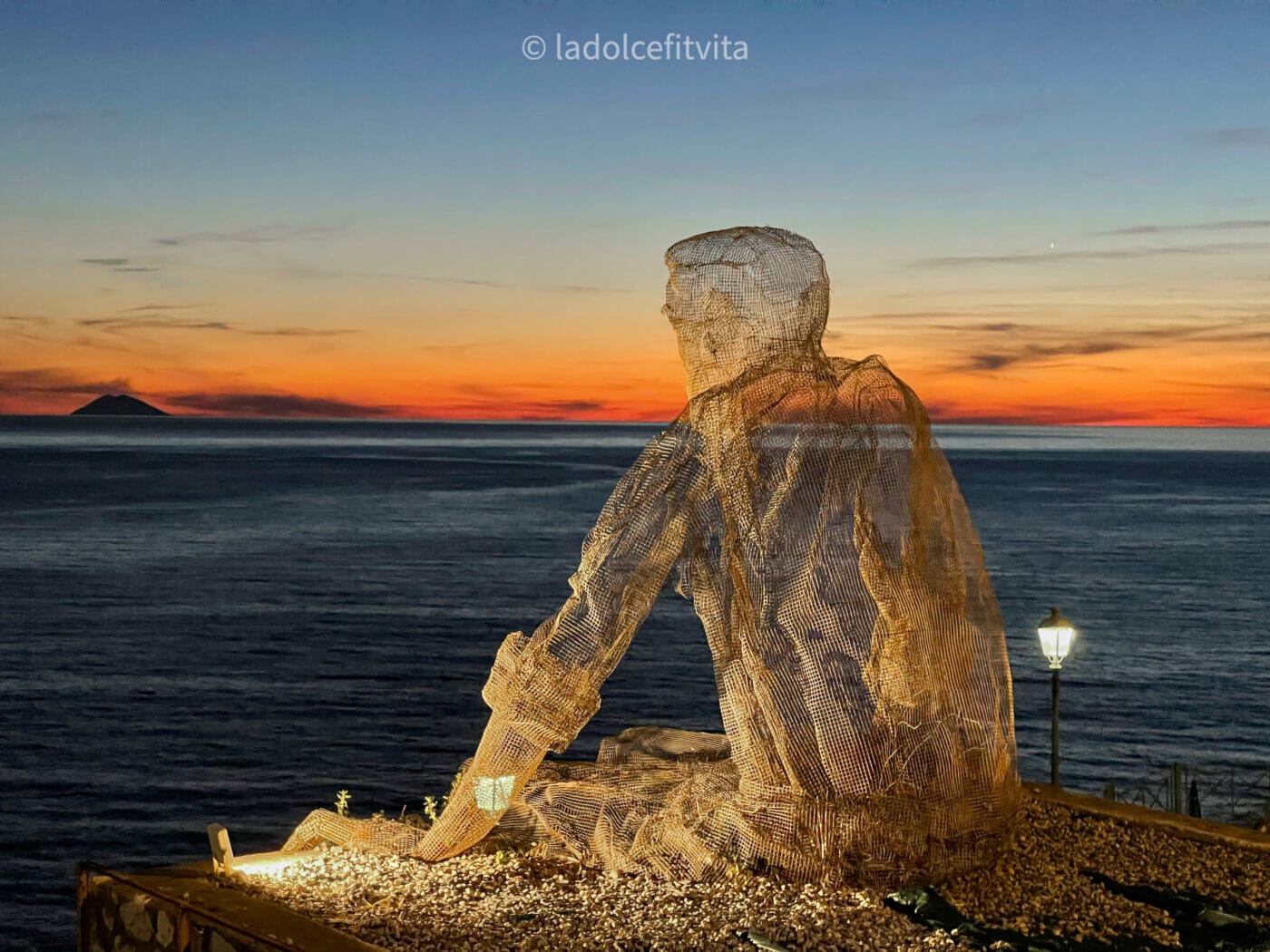Wiremesh sculpture "Il Collezionista dei Venti" at sunset in Pizzo Calabria