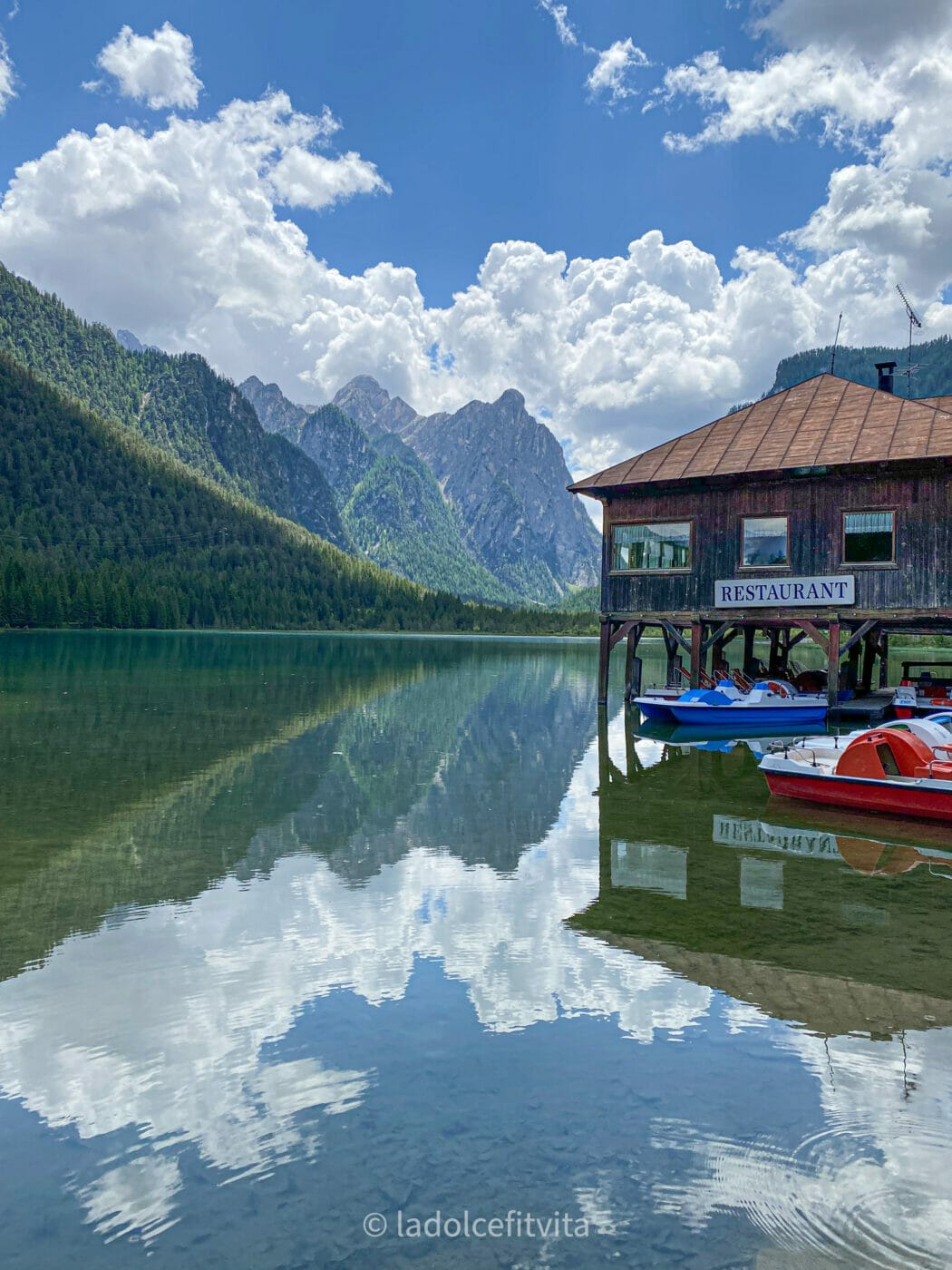 Lakeside restaurant and boat rental at beautiful turquoise Lago di Dobbiaco in Italy