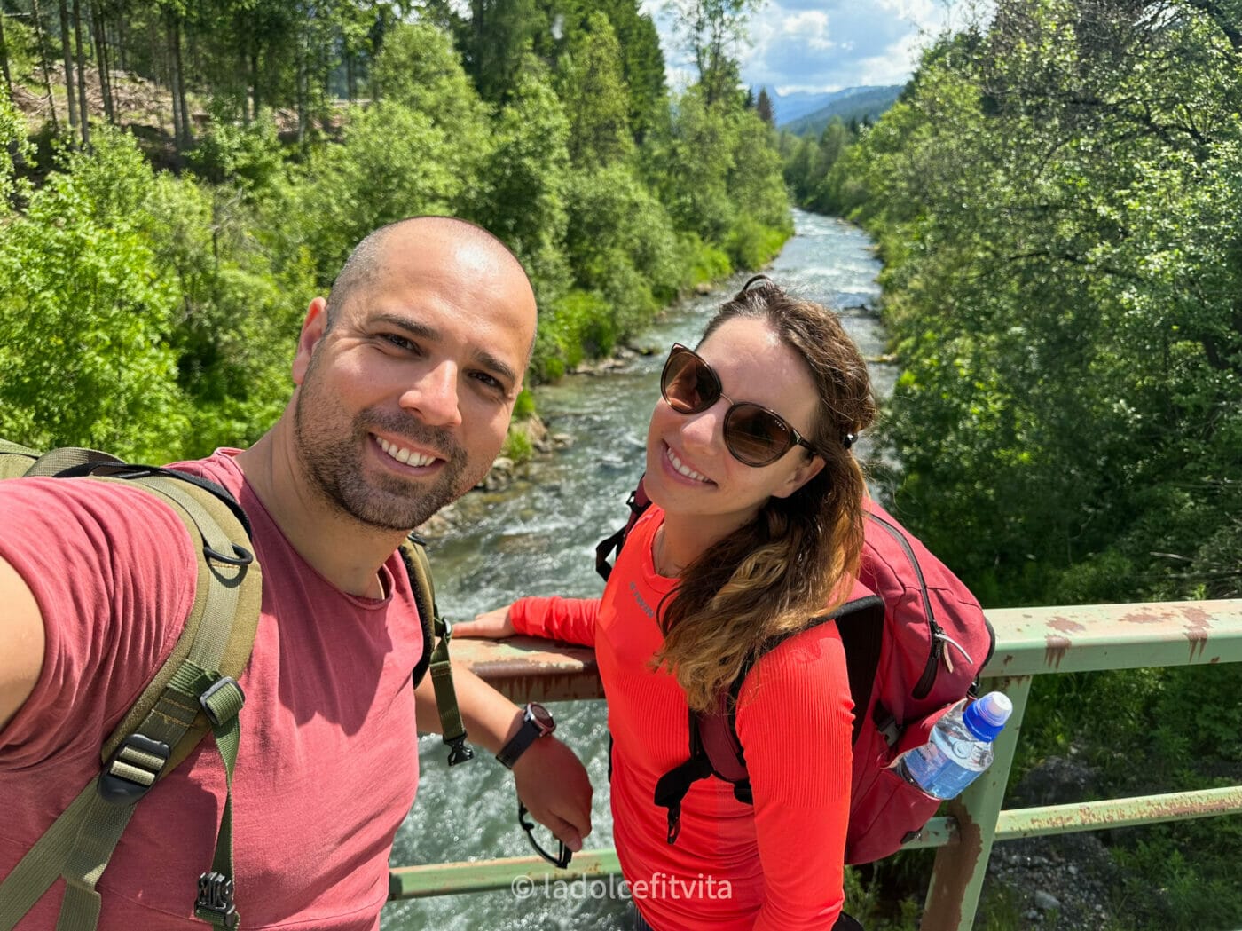a couple smiling for a selfie on a bike path bridge above the Drava river in Eastern Tyrol in Austria