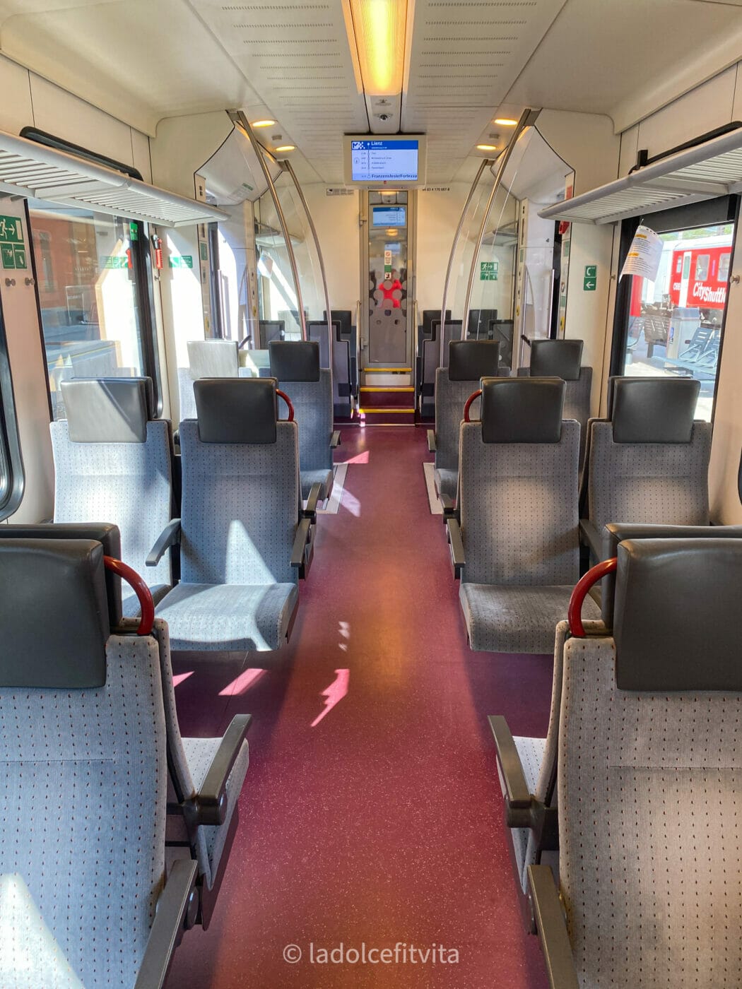 view of train seats and corridor on a regional train in austria