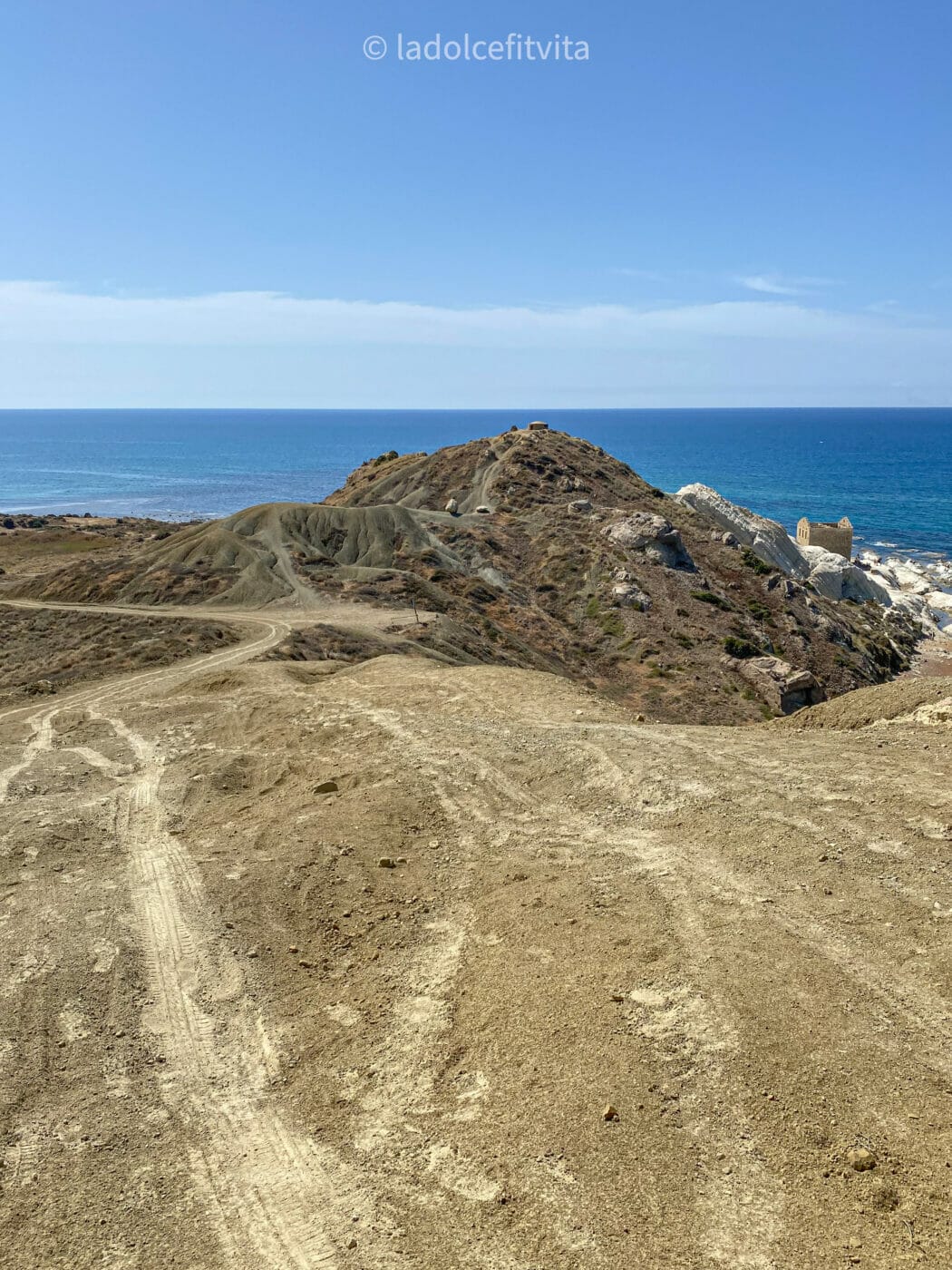 dirt-tracks on a cliffside road skirting the ocean